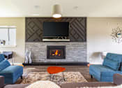Thumbnail 102 of 124 - A modern living room with a fireplace and a flat screen TV mounted above it.