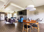Thumbnail 98 of 124 - A modern living room with a fireplace and a dining table set for four.
