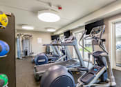 Thumbnail 78 of 124 - A gym with treadmills and elliptical machines.