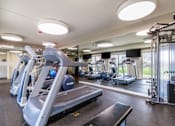 Thumbnail 82 of 124 - A gym with treadmills and elliptical machines.