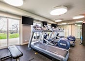 Thumbnail 84 of 124 - A gym with treadmills and a television.