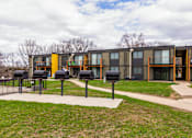 Thumbnail 116 of 124 - A modern building with a yellow and grey exterior and a black fence in front.