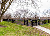 Thumbnail 112 of 124 - A black fence surrounds a grassy area with a tree and a path.