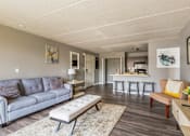 Thumbnail 4 of 124 - A living room with a grey couch and a wooden bench.