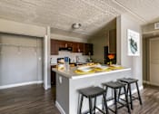 Thumbnail 50 of 124 - A kitchen with a bar stool and a fridge.