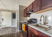 Thumbnail 70 of 124 - A kitchen with a sink, stove, and cabinets.