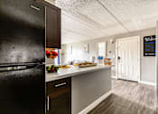 Thumbnail 65 of 124 - A kitchen with a black fridge and a white door.