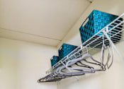 Thumbnail 31 of 124 - A white wall with a shelf and a blue container on it.