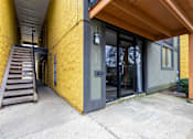 Thumbnail 118 of 124 - A yellow building with a wooden roof and a glass door.