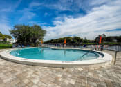 Thumbnail 31 of 47 - a round swimming pool with a fence and chairs around it