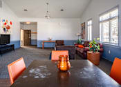 Thumbnail 64 of 66 - A living room with a brown table and orange chairs.