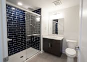 Thumbnail 10 of 27 - A modern bathroom with a walk-in shower and a toilet.