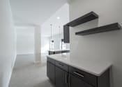 Thumbnail 6 of 27 - A kitchen with a white counter top and black cabinets.