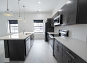 Thumbnail 5 of 27 - A modern kitchen with black cabinets and stainless steel appliances.