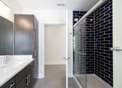 Thumbnail 13 of 27 - A bathroom with a white sink and black cabinets.