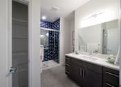 Thumbnail 12 of 27 - A bathroom with a walk-in shower and double sink vanity.