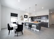 Thumbnail 1 of 27 - A modern kitchen with a dining table and chairs.