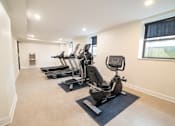 Thumbnail 23 of 27 - A room with a row of treadmills and elliptical machines.