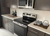 Thumbnail 4 of 27 - A modern kitchen with a stove top oven and microwave above it.