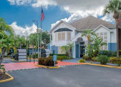 Thumbnail 26 of 31 - a house with a driveway and an flag inExterior at Captiva Club Apartments at 4401 Club Captiva Drive in Tampa, Florida 33615 front of it