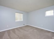 Thumbnail 19 of 50 - an empty living room with carpet and two windows at Centerpointe Apartments, Canandaigua, NY