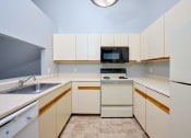 Thumbnail 25 of 50 - a kitchen with white cabinets and appliances and a sink at Centerpointe Apartments, Canandaigua, NY