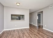 Thumbnail 7 of 50 - an empty living room with a window and a kitchen at Centerpointe Apartments, Canandaigua, NY, 14424