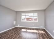 Thumbnail 8 of 50 - an empty living room with wood floors and a window at Centerpointe Apartments, Canandaigua, NY
