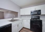 Thumbnail 9 of 50 - a kitchen with white cabinets and black appliances and a sink at Centerpointe Apartments, Canandaigua