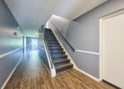 Thumbnail 32 of 50 - a staircase in a home with wood floors and blue walls at Centerpointe Apartments, Canandaigua