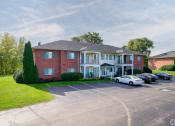 Thumbnail 40 of 50 - a large brick house with cars parked in front of it at Centerpointe Apartments, Canandaigua, NY, 14424