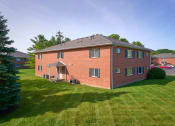 Thumbnail 48 of 50 - a red brick house with a green lawn and a tree at Centerpointe Apartments, Canandaigua, New York
