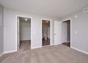 Thumbnail 14 of 50 - a living room with a carpeted floor and a door to a bathroom at Centerpointe Apartments, Canandaigua, New York