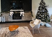 Thumbnail 92 of 111 - A living room with a fireplace, a chair, a table, and a Christmas tree at Woodland Ridge, Woodridge, Illinois, 60517
