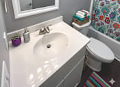 Thumbnail 61 of 67 - A bathroom with a white sink and a mirror with lights above it.