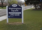 Thumbnail 3 of 17 - A sign for Washington Square Apartments is displayed in front of a tree.