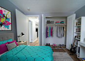 Thumbnail 24 of 35 - A room with a bed, a guitar, a bookshelf and a painting on the wall.