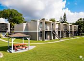 Thumbnail 38 of 47 - A row of modern houses with a picnic table in the foreground.