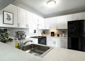 Thumbnail 2 of 77 - A modern kitchen with black appliances and white cabinets. at CenterPointe Apartments & Townhomes, Canandaigua, 14424