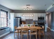 Thumbnail 9 of 29 - A modern kitchen with a dining table and chairs.