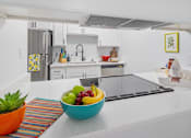 Thumbnail 1 of 35 - A bowl of fruit sits on a kitchen counter.