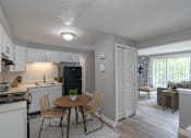 Thumbnail 6 of 17 - A kitchen with a table and chairs in the middle of the room.