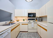 Thumbnail 5 of 77 - A small, modern kitchen with white appliances and cabinets. at CenterPointe Apartments & Townhomes, Canandaigua, 14424
