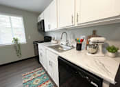 Thumbnail 5 of 67 - A kitchen with a black dishwasher and white cabinets. at Highview Manor Apartments, Fairport, NY, 14450