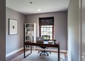 Thumbnail 12 of 29 - A room with a desk and a laptop on it.
