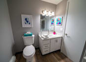 Thumbnail 29 of 35 - A white toilet sits next to a sink in a small bathroom.