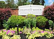 Thumbnail 63 of 67 - A sign for Highview Manor Apartments & Townhomes is surrounded by flowers.