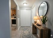 Thumbnail 42 of 66 - A hallway with a wooden bench, a lamp, and a potted plant. at Willowbrooke Apartments & Townhomes, Brockport, 14420
