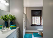 Thumbnail 13 of 29 - A bathroom with a toilet, sink, and a window.