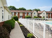 Thumbnail 67 of 67 - A white picket fence separates a sidewalk from a row of townhouses.